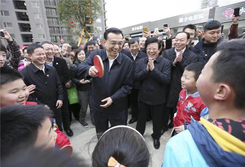 图为李克强在贵阳考察时，一群孩子围住总理“邀约”打乒乓球。